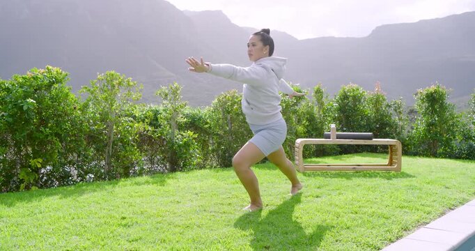 Starting from prayer pose, Asian woman performing flowing yoga on lawn by bench for strength