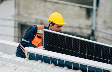 Technician installs solar panel on rooftop in urban location during daylight hours