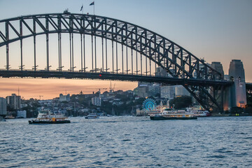 Obraz premium Sydney Harbour Bridge and Luna Park illuminated at dusk with city skyline behind