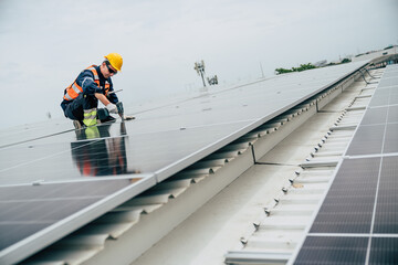 Solar panel installation on rooftop by technician in industrial area during overcast weather