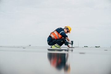 Construction worker installing solar panels on a rooftop during a cloudy day in an urban environment