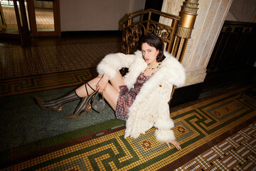 Elegant woman in stylish attire lounging indoors.
