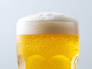 Golden beer with float in the glass in white background. Close up shot.