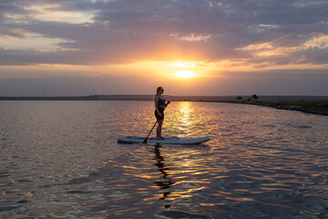 Sport woman on sup board. A beautiful young woman relaxes on a SUP board. Standup paddleboarding