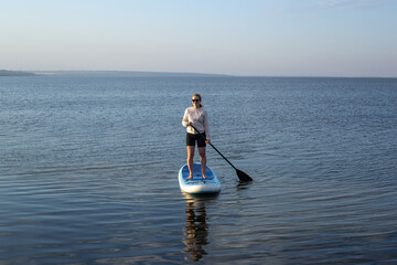 Young Attractive Woman on Stand Up Paddle Board, SUP, Active Life Concept. Woman paddleboarding
