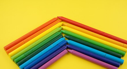 Colorful wax crayons arranged neatly on a bright yellow background, vibrant and playful composition for education, creativity, art, or back-to-school themes.