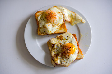 High angle view of plate with two slices of toast covered with two fried eggs. Photo taken July 31st, 2025, Zurich, Switzerland.