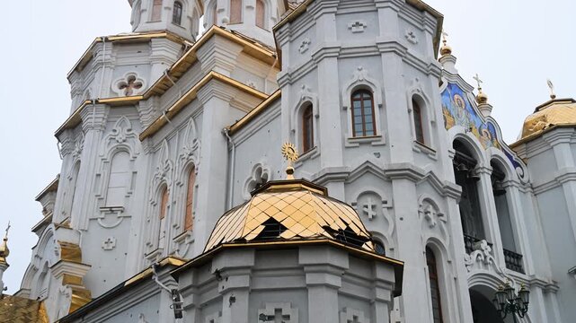 Tilt-up view of the Holy Myrrh-Bearing Women Church in Kharkiv. The golden dome is damaged and the walls are pockmarked by shrapnel from a Russian strike during the war.