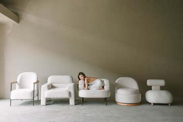 Young woman interacting with modern furniture in a minimalist setting.