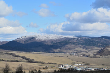 Snow-capped peaks of hills and mountains in an agricultural landscape
