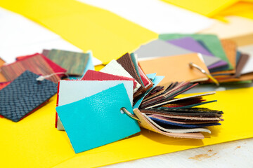 A variety of colored fabric samples arranged on a bright yellow surface