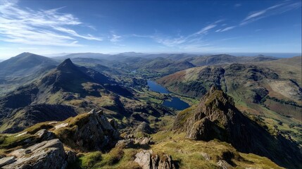 Obraz premium Breathtaking view of a valley with a serene lake surrounded by mountains under clear blue skies during a sunny day