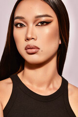 Close-up portrait of a young Asian woman with bold makeup.