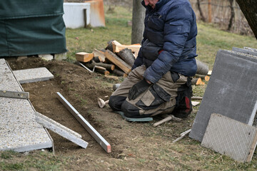 Laying stone paving around a house in the village in traditionally way
