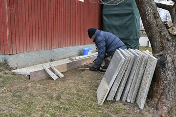 Laying stone paving around a house in the village in traditionally way