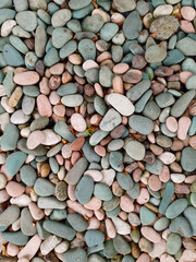 A dense collection of various-sized pebbles and small stones, predominantly in shades of teal, blue-grey, and pale pink. Related to natural textures, backgrounds, geology, decorative elements, pattern