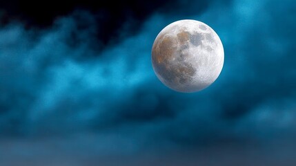 Large white moon is shining brightly in the sky above a dark blue sky. The moon is surrounded by a few clouds, which add to the moody atmosphere of the scene