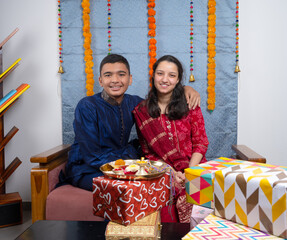 Loving brother and sister with gift box celebrating traditional Indian festival like Rakshabandhan...