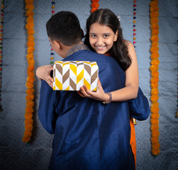 Man with surprise gifts for his sister on the occasion of traditional Indian festival like...