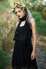 Elegant model with floral crown poses in a natural setting during golden hour