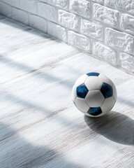 Soccer Ball on Sunlit Wooden Floor with Textured White Wall