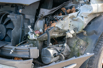 Car awaiting repair in a body shop with the bumper removed. Transportation accident scene with a broken car.