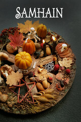 Samhain greeting card. wiccan altar with wheel of the year on dark background. candles, skeleton, amulets and magic things. witchcraft, esoteric ritual for samhain holiday.