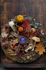 wiccan altar with wheel of the year on wooden background. crystals, bird skull, pentacle and magic things. witchcraft, esoteric ritual for samhain holiday. autumn season