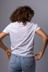 Young Woman In Plain White T-Shirt And Jeans Posing On Gray Background