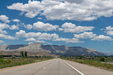 Low angle view of Mt. Garfield near De Beque, CO, USA consisting of sedimentary rock, primarily sandstone and shaleformations against a blue sky with large cumulus clouds