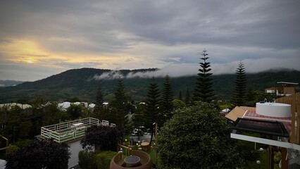  Phetchabun, Thailand : Outdoor jacuzzi with mountain view at sunrise surrounded by fog, trees and...