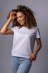 Young Woman In Plain White T-Shirt And Jeans Posing On Gray Background