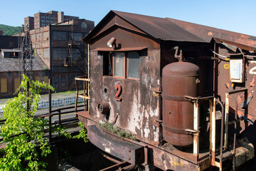 Rusty industrial locomotive at abandoned and dilapidated remnants like blast furnaces of the old steel manufacturing plant in Bethlehem, Pennsylvania, USA