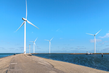 Modern wind turbines on the breakwater of former working island Neeltje Jans on the Oosterscheldekering used to complete the Delta Works storm surge barrier in Zeeland, the Netherlands