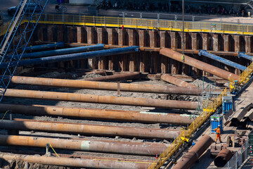 High angle view of excavation pit with sheet pile wall and large steel pipes for excavation pit shoring or supporting the sides of a construction site