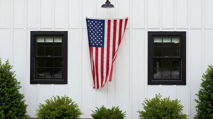 American flag waving proudly on modern farmhouse exterior, celebrating patriotism and freedom, summer day, creating a sense of national pride - Powered by Adobe