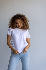 Young Woman In Blank White T-Shirt And Jeans Posing On Neutral Background