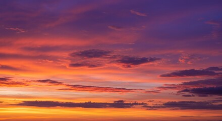 Dramatic sunset with vivid hues. Clouds are scattered, colored with orange, red, purple, and hints of yellow and blue