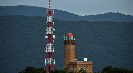 Communication tower and brick radar tower against green mountains