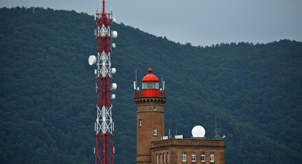Communication tower and brick radar tower against green mountains