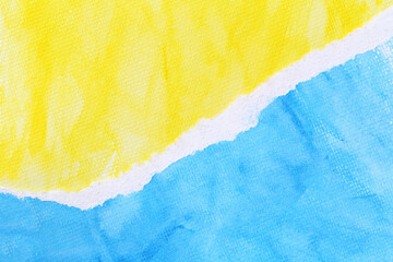 Art paper with yellow and blue watercolors on the drawing paper and torn overlapping.