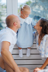Family enjoys a joyful moment together as they play with their little girl in a bright room