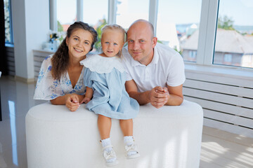 Family enjoys time together in bright indoor space with child content and smiling