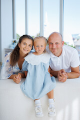 Family portrait with young child in cozy modern living room during daytime