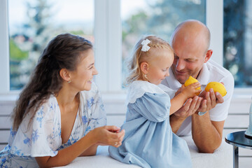 Family enjoys time together in a bright room while playing with lemons in summer