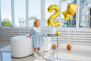 Celebrating a child's birthday with pastel decor and golden balloons in a bright room