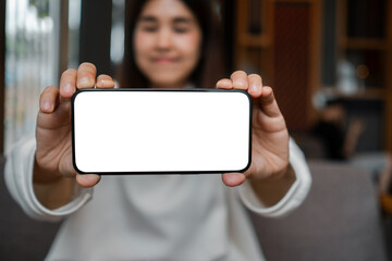 Close-up of a woman displaying a smartphone with a blank screen, perfect for mockup designs or app presentations.
