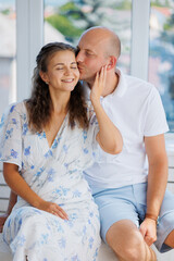 Happy couple enjoys a romantic moment indoors on a sunny day