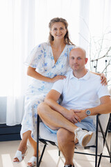 Couple poses together in bright, airy indoor space during a sunny day