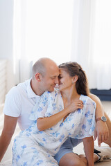Couple enjoying a tender moment together in a bright, cozy living room during daytime